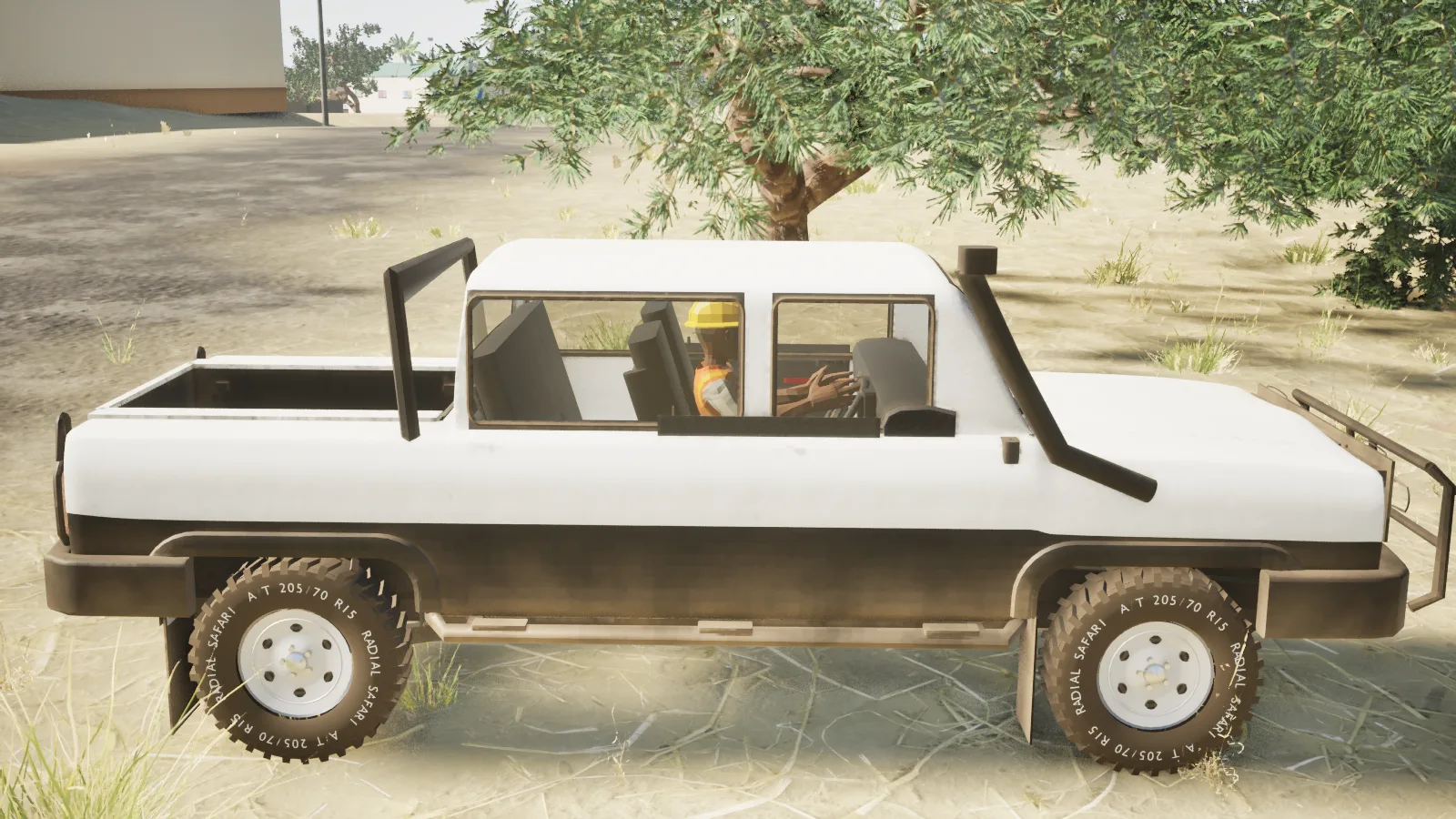 Bílý pickup s řidičem v přilbě stojí pod stromem na písku